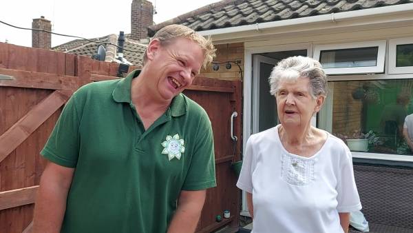 Man and woman laughing together in front of house