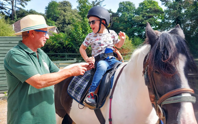Thanet Disabled Riding Centre - boy on a horse being supported by a man